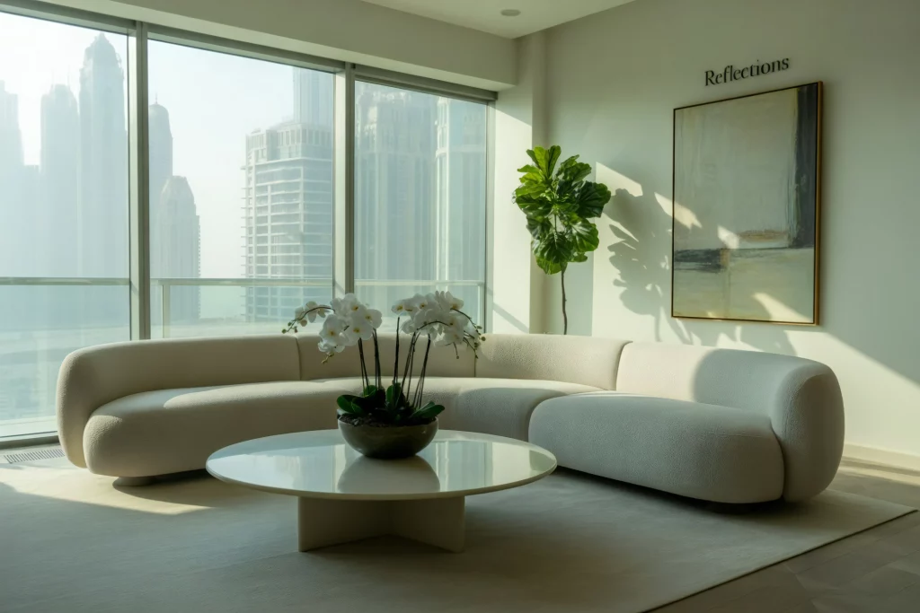 Modern living room with curved sofa, orchid centerpiece, abstract art, and floor-to-ceiling windows overlooking skyscrapers.
